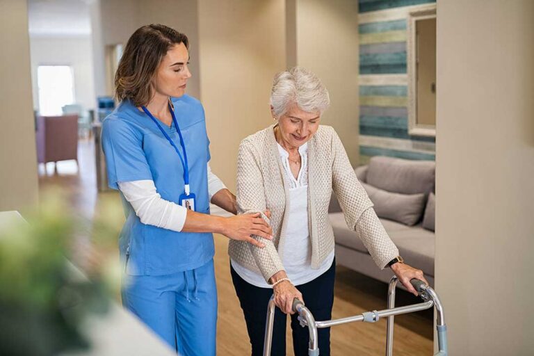 Adult child reviews a medication organizer with an older relative at a bright kitchen table.