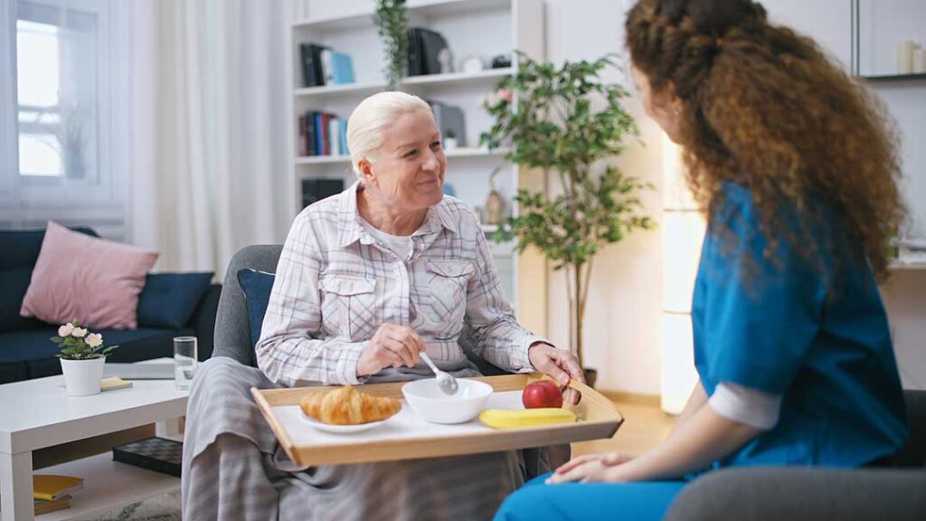 Adult daughter reviewing a medication list with an older parent at a bright kitchen table.