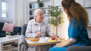 Adult daughter reviewing a medication list with an older parent at a bright kitchen table.